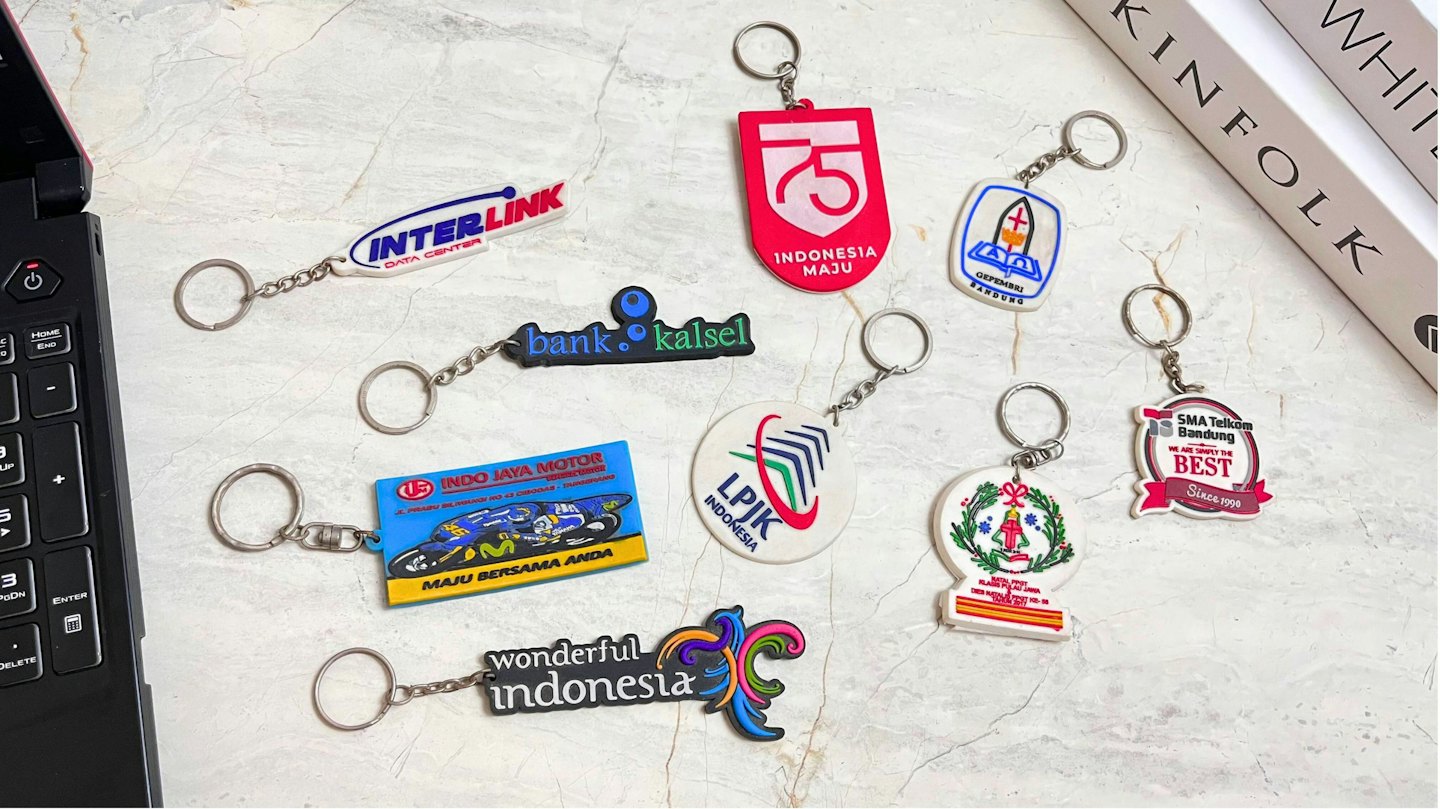 Individuelle Schlüsselanhänger mit verschiedenen Logos auf Marmor.