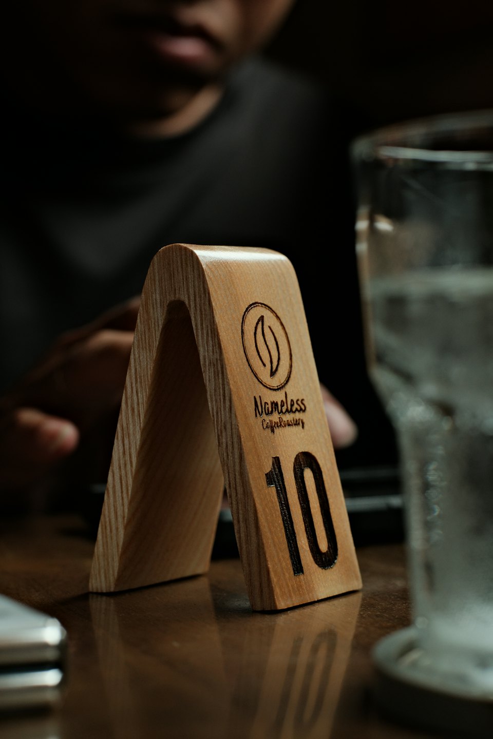 Holzschild mit dem Logo der Nameless Coffee Roastery.